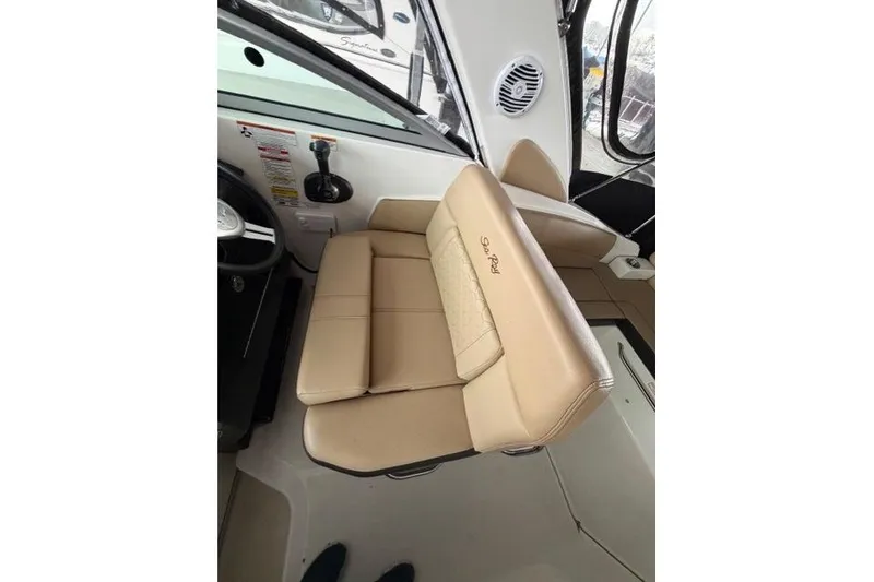 Slide: The Image of 2018 Sea Ray Sundancer 260 interior with beige seating and steering area. - 8