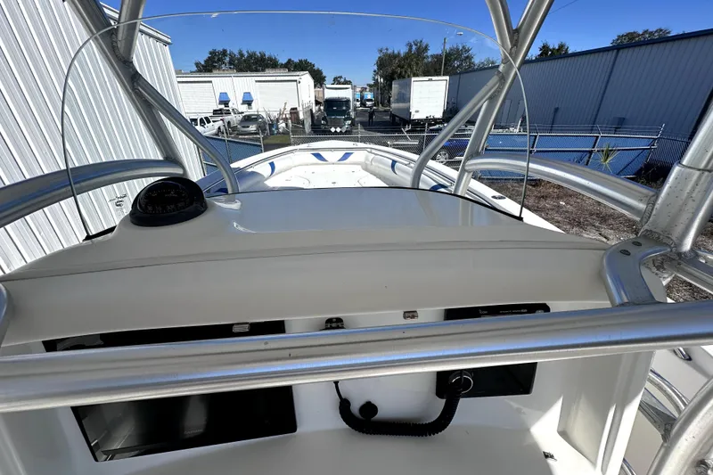 Slide: The Image of 2007 Boston Whaler 320 Outrage boat console with compass and railing, docked outdoors. - 23