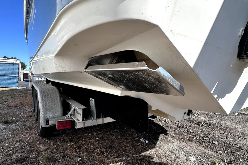 Slide: The Image of 2007 Boston Whaler 320 Outrage on trailer, showing hull and trim tab details. - 24
