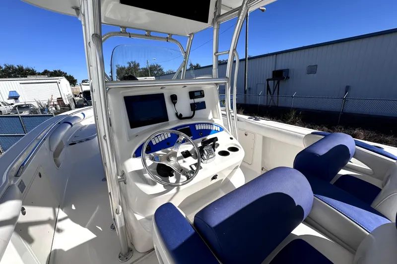 Slide: The Image of 2007 Boston Whaler 320 Outrage boat cockpit with steering wheel and blue seating. - 7