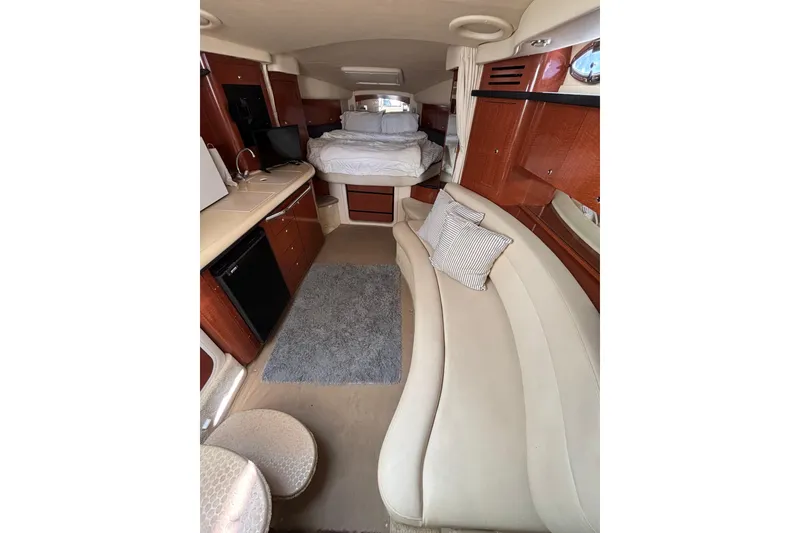 Slide: The Image of 2003 Sea Ray 340 Sundancer interior with cozy seating, kitchenette, and bed. - 12