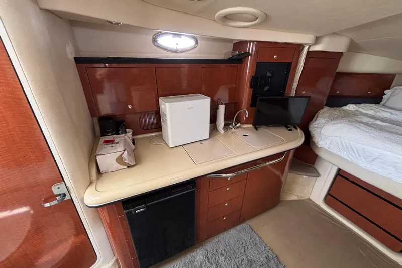 Slide: The Image of 2003 Sea Ray 340 Sundancer cabin interior with kitchenette, mini fridge, and bed. - 13