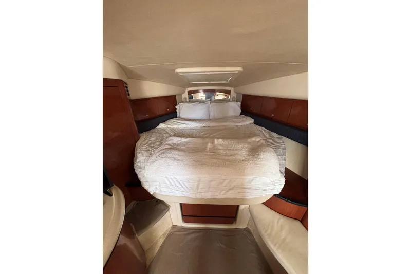 Slide: The Image of Interior cabin of 2003 Sea Ray 340 Sundancer with cozy bed and wooden accents. - 14