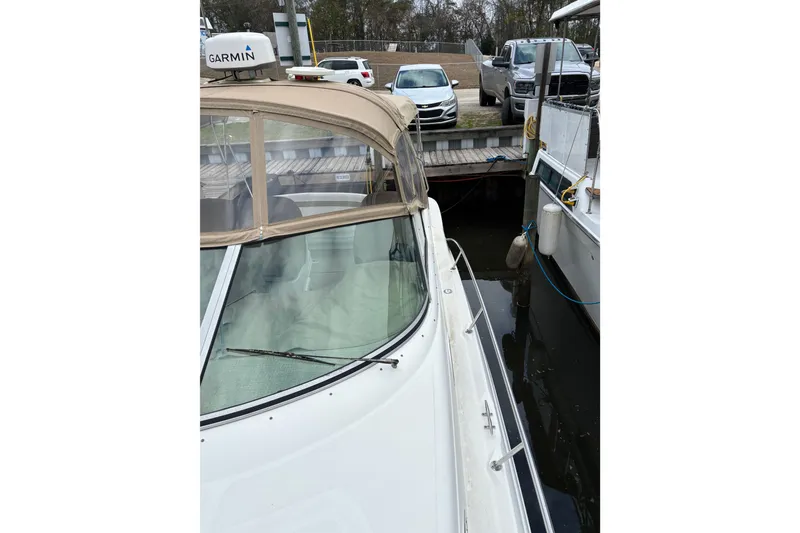 Slide: The Image of 2003 Sea Ray 340 Sundancer docked, featuring tan canopy and Garmin equipment. - 19