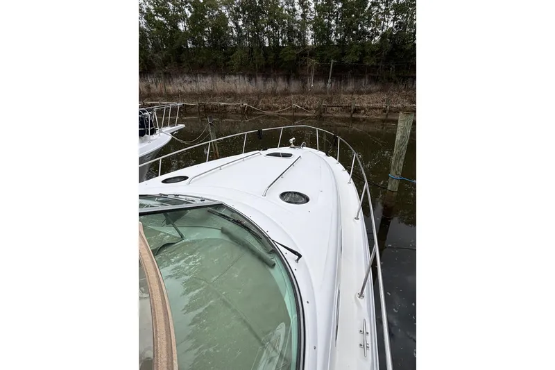 Slide: The Image of 2003 Sea Ray 340 Sundancer docked, showcasing sleek white deck and railings. - 22