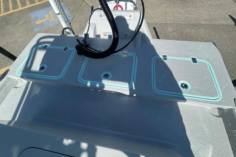 Slide: The Image of 2026 Cayuco Boats Lynx 18 deck with storage compartments and control panel. - 16