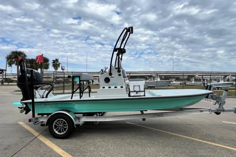 Slide: The Image of Cayuco Boats Lynx 18, 2026 model, on trailer under cloudy sky. - 2