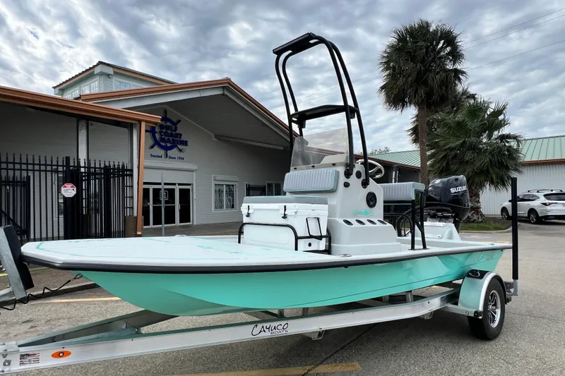 Slide: The Image of 2026 Cayuco Boats Lynx 18 on trailer, parked outside a marine store. - 5