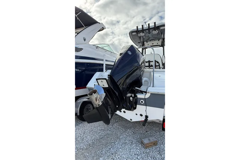 Slide: The Image of 2023 Tidewater 220 LXF boat with powerful outboard motor, parked on gravel. - 10