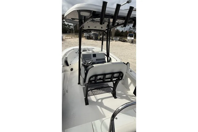 Slide: The Image of 2023 Tidewater 220 LXF boat interior with helm and seating, parked outdoors. - 18