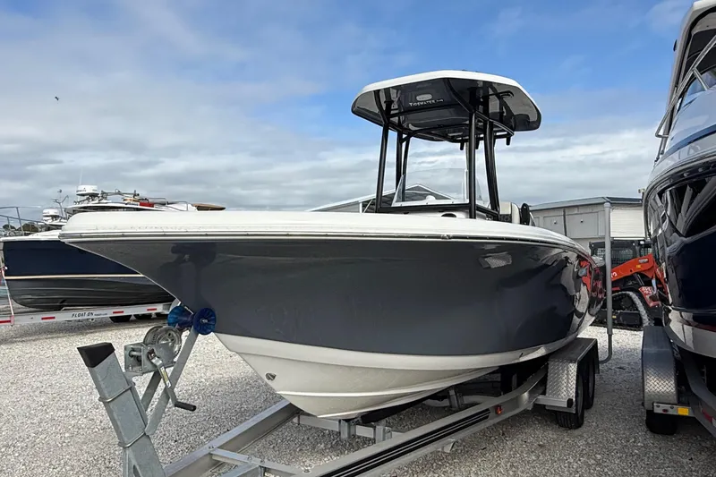 Slide: The Image of 2023 Tidewater 220 LXF boat on trailer, displayed outdoors under cloudy sky. - 2