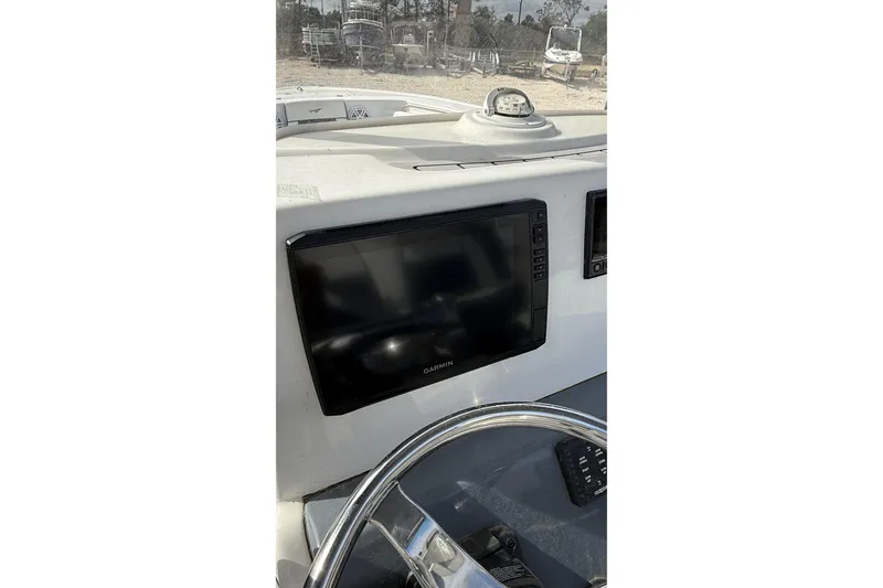 Slide: The Image of 2023 Tidewater 220 LXF boat dashboard with Garmin display and steering wheel. - 21