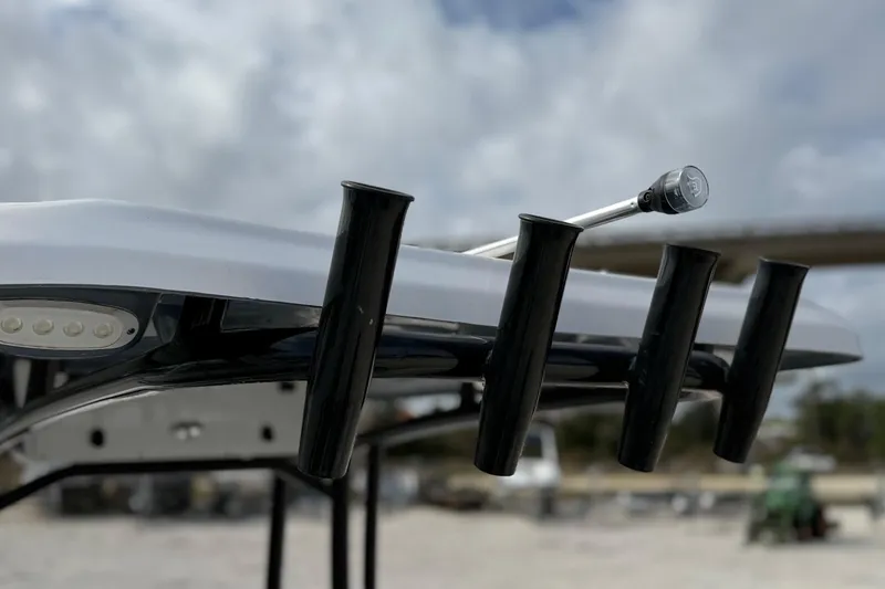 Slide: The Image of 2023 Tidewater 220 LXF boat with rod holders and LED lights under cloudy sky. - 26
