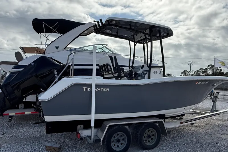 Slide: The Image of 2023 Tidewater 220 LXF boat on trailer, parked outdoors under cloudy sky. - 3