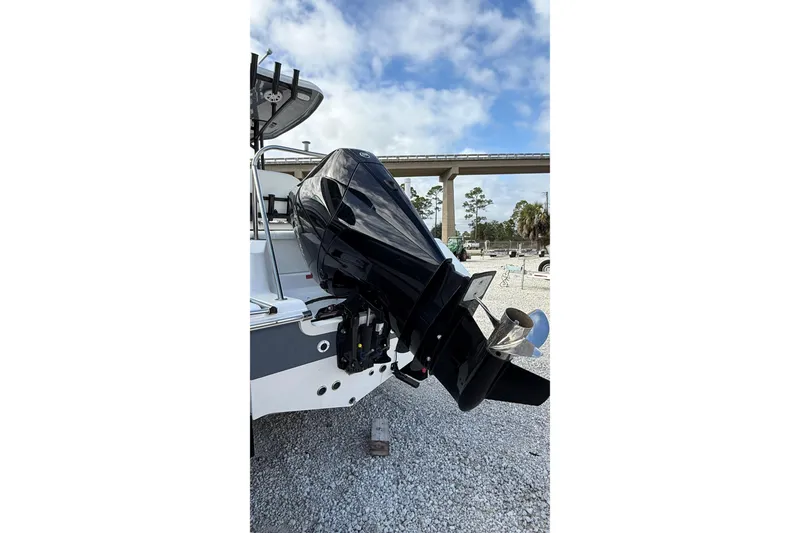 Slide: The Image of 2023 Tidewater 220 LXF boat with powerful outboard motor, parked on gravel. - 6