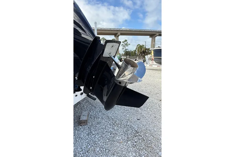 Slide: The Image of 2023 Tidewater 220 LXF boat propeller on gravel, under a blue sky. - 7