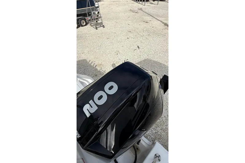 Slide: The Image of 2023 Tidewater 220 LXF boat with a powerful outboard motor in a gravel lot. - 9