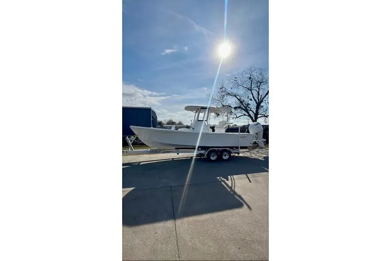 Slide: The Image of 2026 Pair Customs 24 Center Console MV boat on trailer under bright sun. - 5