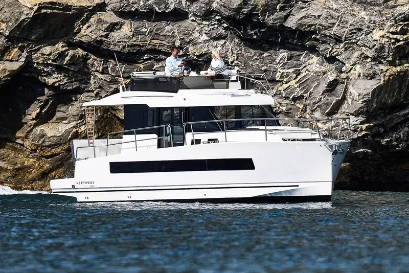 Slide: The Image of 2025 Northman 1300 yacht cruising near rocky cliffs. - 1