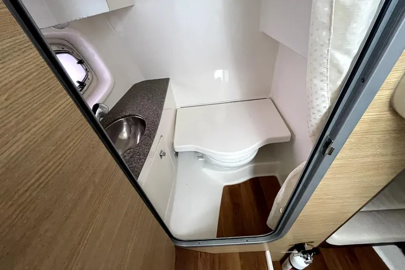 Slide: The Image of 2013 Chaparral 327 SSX boat bathroom with sink, toilet, and wooden flooring. - 12