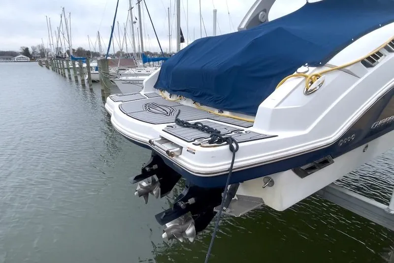 Slide: The Image of 2013 Chaparral 327 SSX boat docked with covered deck and dual propellers. - 19