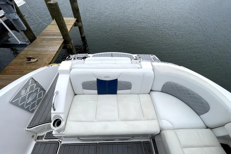 Slide: The Image of 2013 Chaparral 327 SSX boat with white seating, docked by wooden pier. - 3