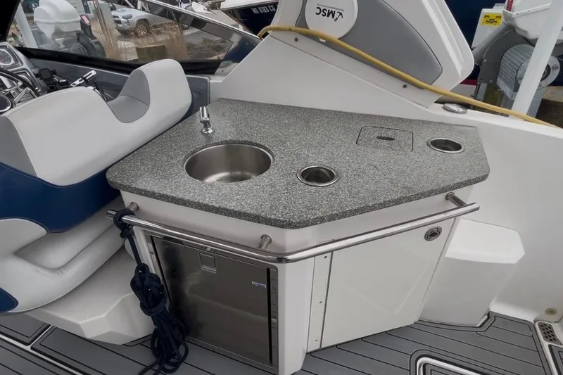Slide: The Image of 2013 Chaparral 327 SSX boat interior with sink, countertop, and seating area. - 7