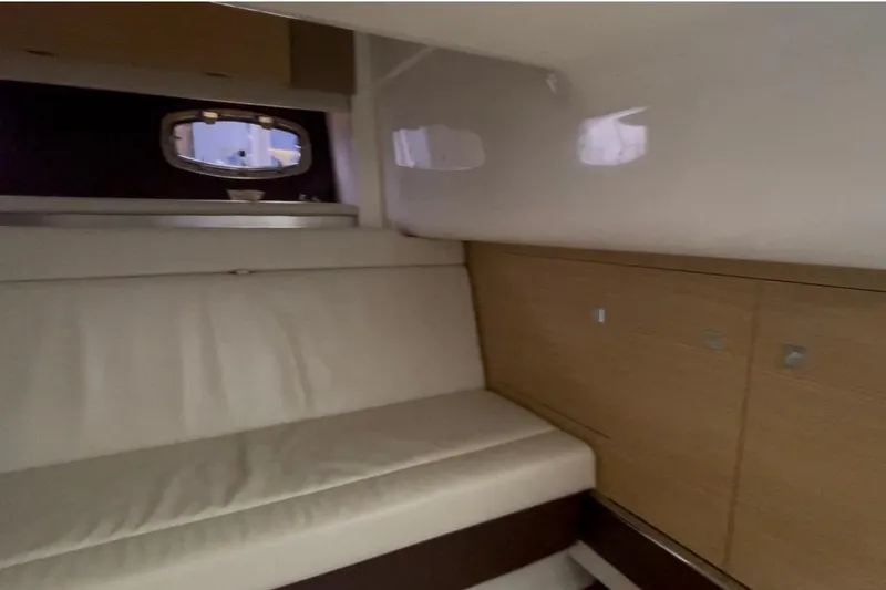 Slide: The Image of Interior of 2013 Chaparral 327 SSX boat with beige seating and wooden cabinetry. - 9