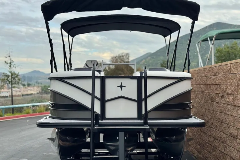 Slide: The Image of 2026 Berkshire 21CL STS pontoon boat with canopy, parked near mountains. - 2
