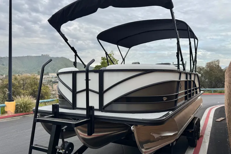 Slide: The Image of 2026 Berkshire 21CL STS pontoon boat with canopy on a trailer, scenic background. - 3