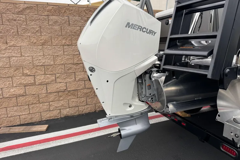 Slide: The Image of 2026 Berkshire 21CL STS boat with Mercury outboard motor, parked near a brick wall. - 7