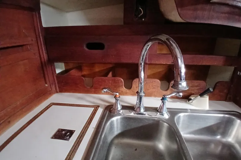 Slide: The Image of 1977 Tartan 37 yacht kitchen sink with wooden cabinetry and chrome faucet. - 10