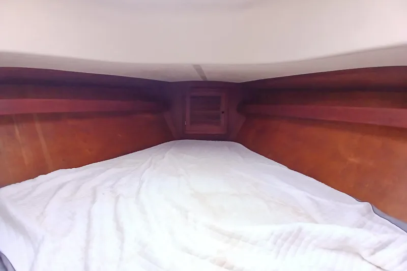 Slide: The Image of Cozy cabin interior of a 1977 Tartan 37 sailboat with wooden paneling and white bedding. - 13