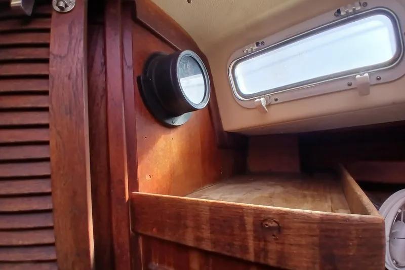 Slide: The Image of Interior of a 1977 Tartan 37 sailboat with wooden paneling and a porthole window. - 14