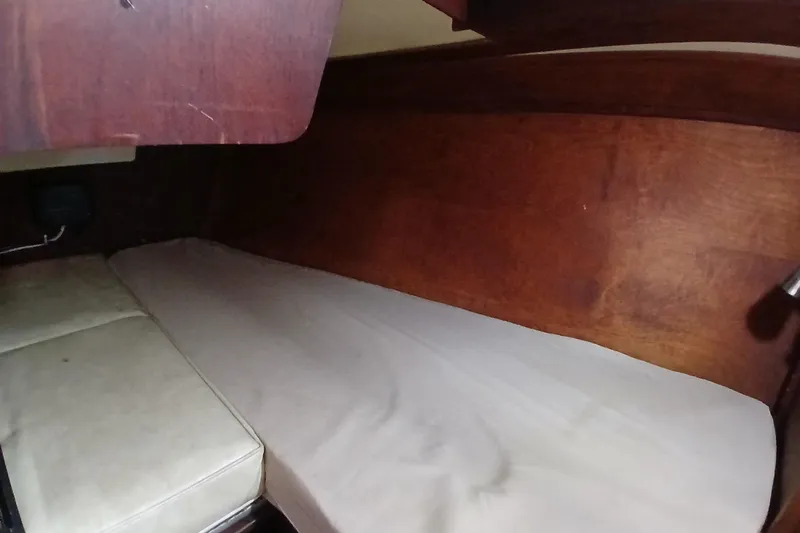 Slide: The Image of Interior cabin of a 1977 Tartan 37 sailboat with wooden paneling and a cushioned berth. - 20