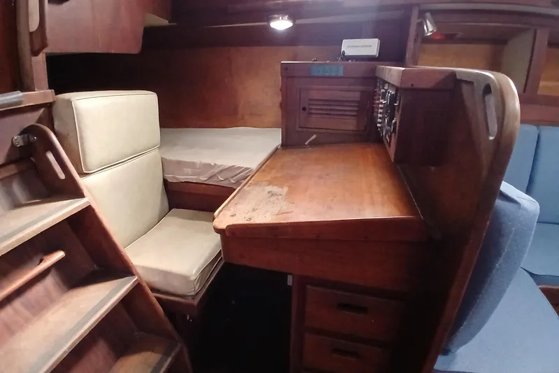 Slide: The Image of 1977 Tartan 37 sailboat interior with wooden desk and seating area. - 22