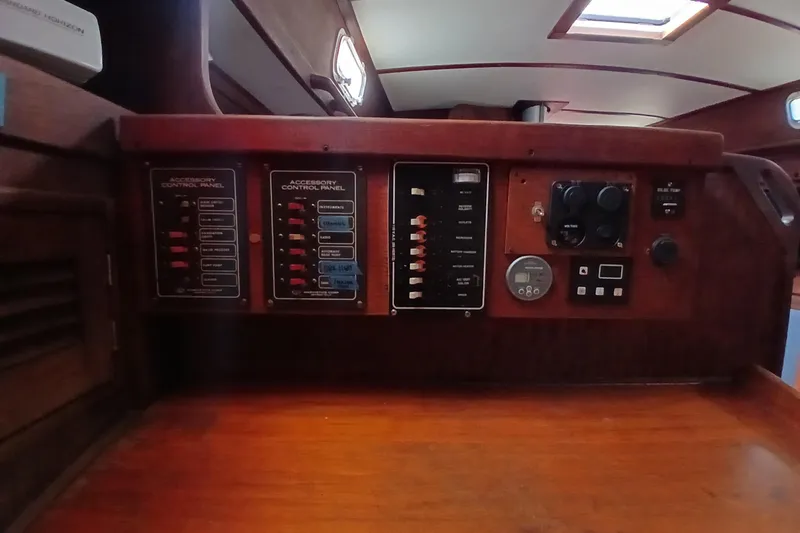 Slide: The Image of 1977 Tartan 37 sailboat control panel with switches and gauges in wooden interior. - 23