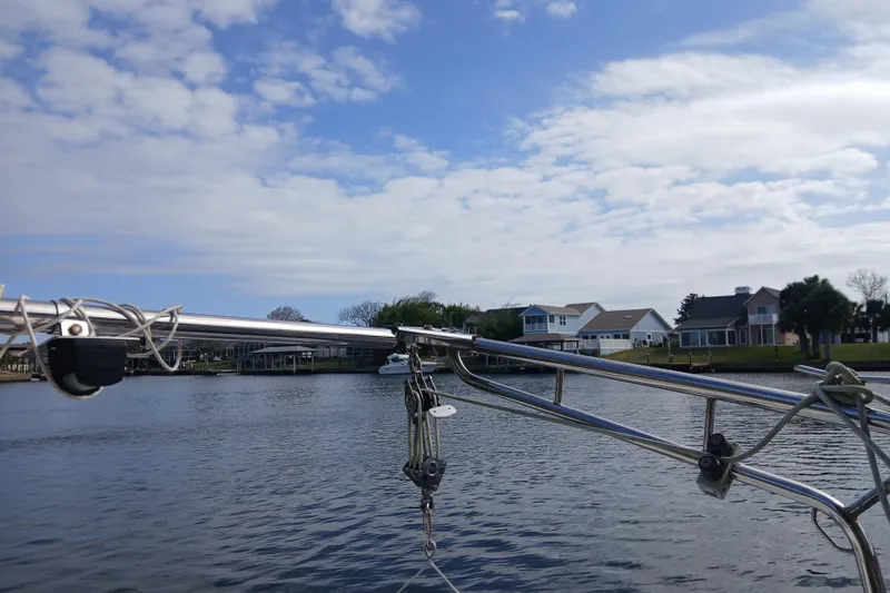 Slide: The Image of Sailboat rigging on a Tartan 37, 1977, with waterfront homes and blue sky background. - 30