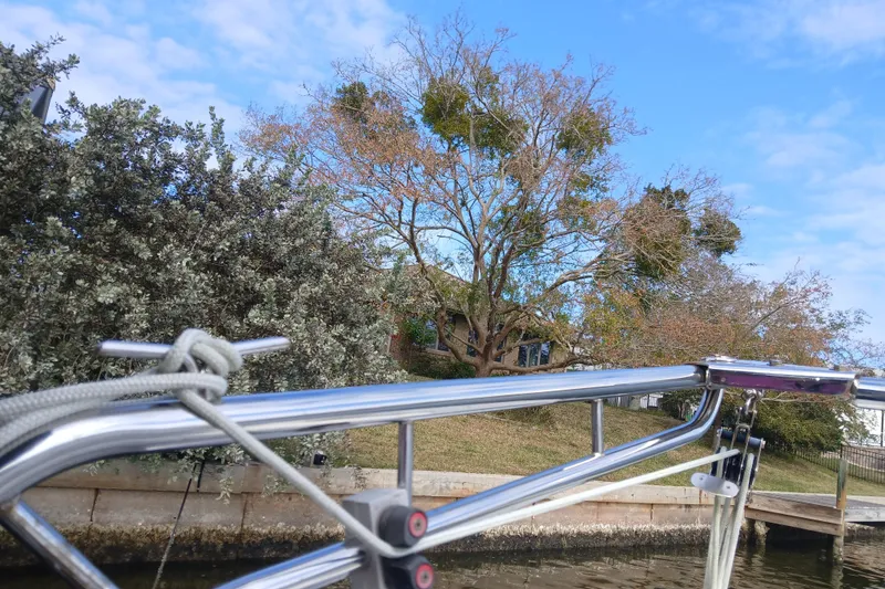 Slide: The Image of Sailboat railing with trees and house in the background, Tartan 37, 1977 model. - 31