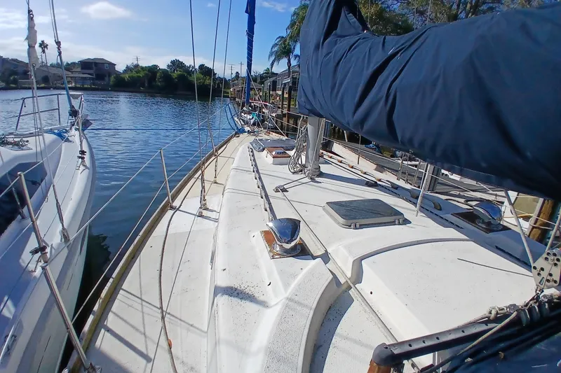 Slide: The Image of 1977 Tartan 37 sailboat docked on a calm river, surrounded by greenery. - 36