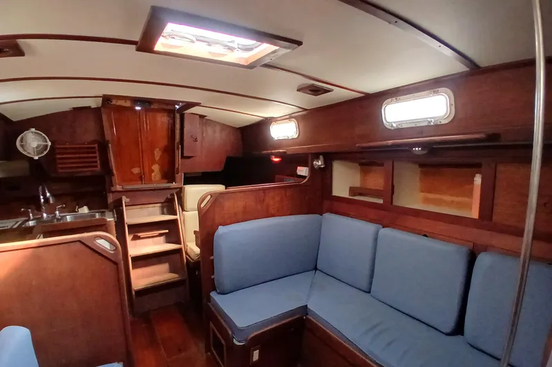 Slide: The Image of Interior of a 1977 Tartan 37 sailboat with wooden finish and blue seating. - 5