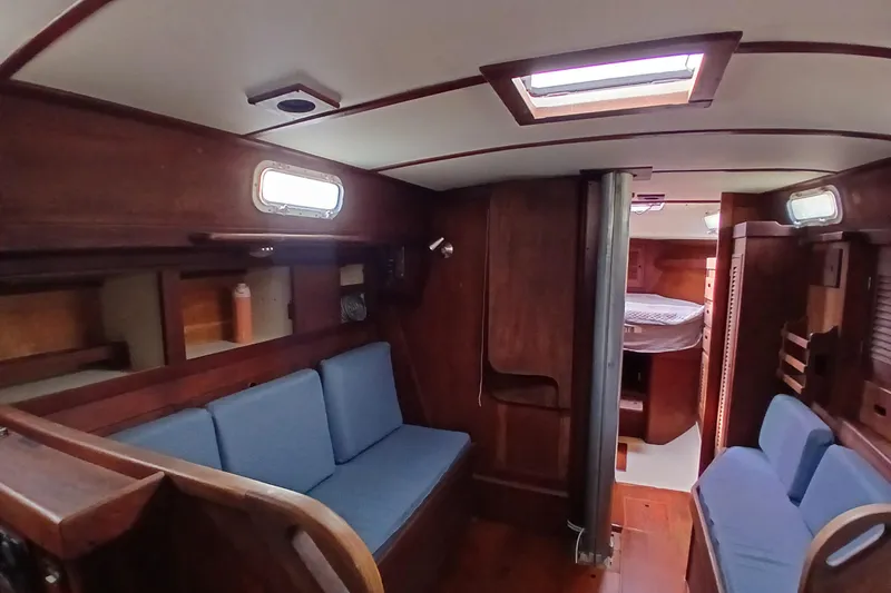 Slide: The Image of Interior of a 1977 Tartan 37 sailboat with wooden furnishings and blue seating. - 6