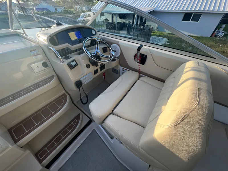 Slide: The Image of 2020 Regal 26 XO boat cockpit with steering wheel and beige seating. - 14