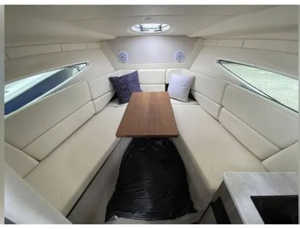 Slide: The Image of 2020 Regal 26 XO cabin interior with seating, table, and cushions. - 30