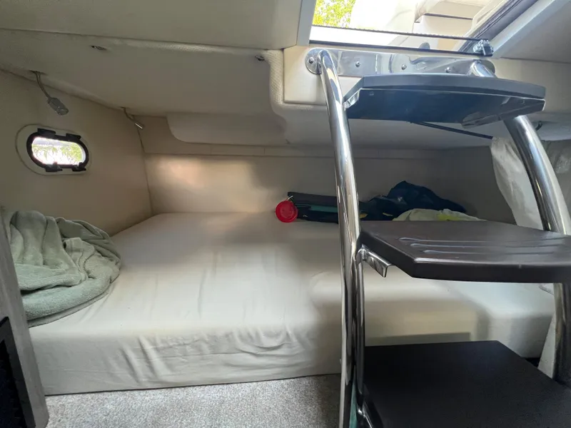 Slide: The Image of 2020 Regal 26 XO cabin interior with bed and ladder, featuring a small window. - 42