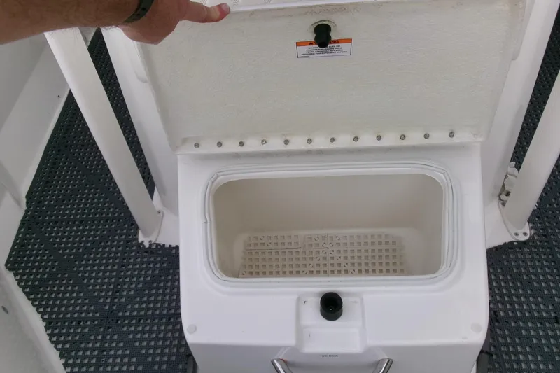 Slide: The Image of 2023 Bayliner Trophy T20CC boat storage compartment with open lid, showcasing interior space. - 11