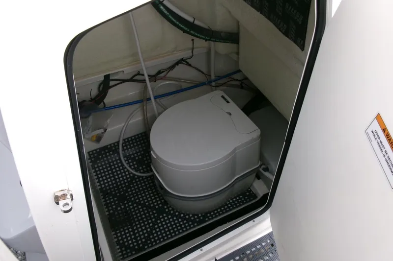 Slide: The Image of 2023 Bayliner Trophy T20CC boat interior with compact marine toilet. - 13