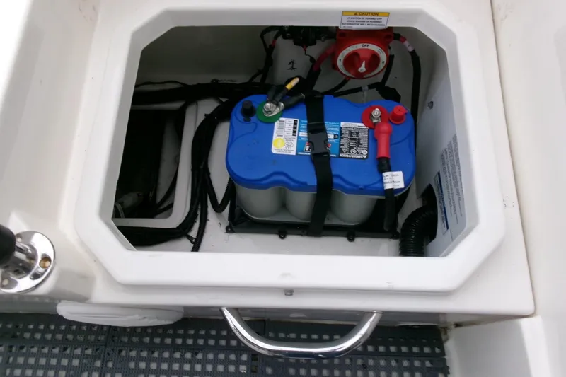Slide: The Image of Battery compartment of 2023 Bayliner Trophy T20CC boat, featuring a secured marine battery. - 23