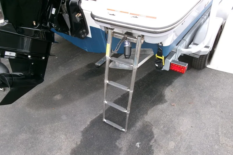 Slide: The Image of 2023 Bayliner Trophy T20CC boat with ladder and trailer on pavement. - 28