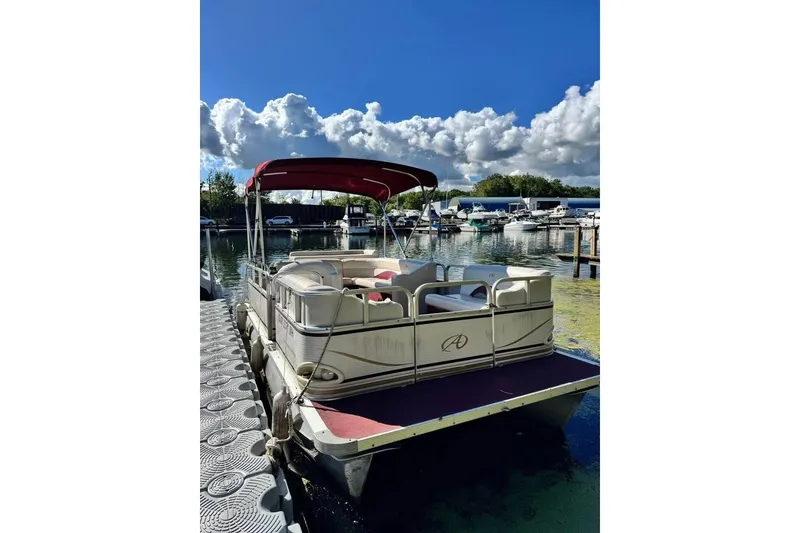 Slide: The Image of 2008 Avalon Catalina 18' pontoon boat docked under a blue sky with clouds. - 5